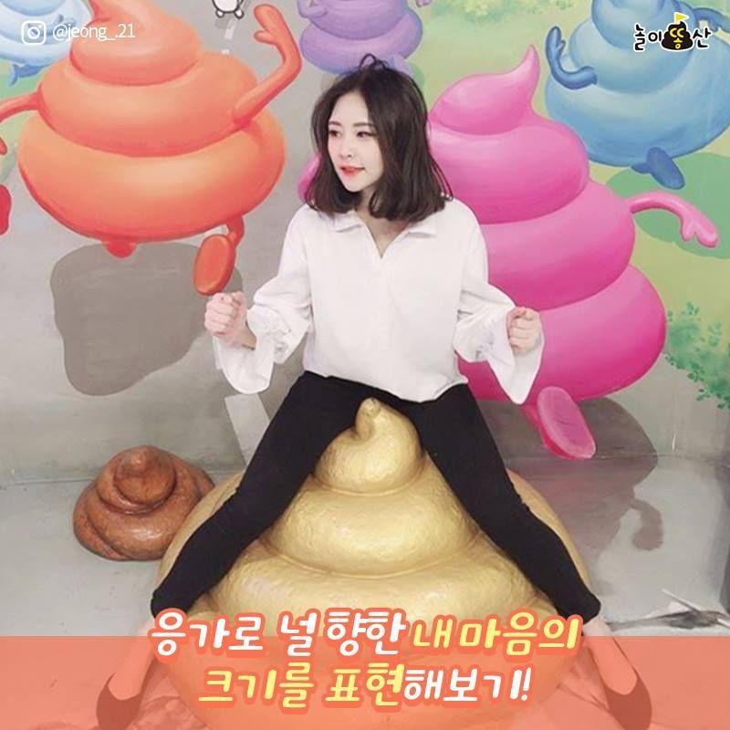 首爾大便主題展覽，一位成年男子站在馬桶形狀雕塑前，背景是現代藝術設計。